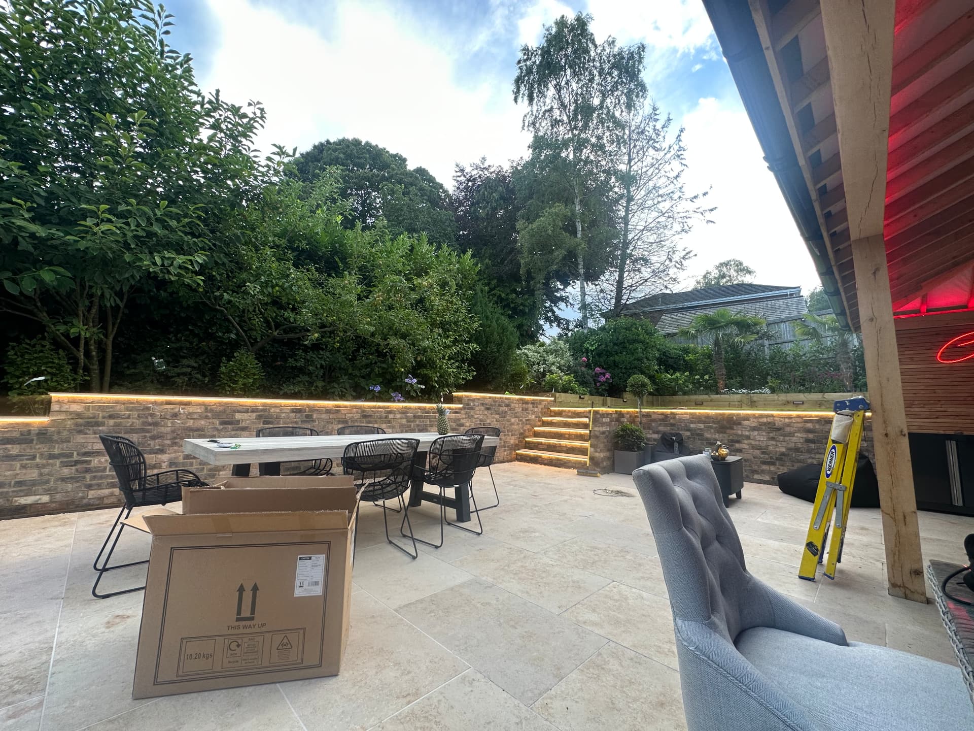 Garden patio with brick retaining walls and warm LED strip lighting